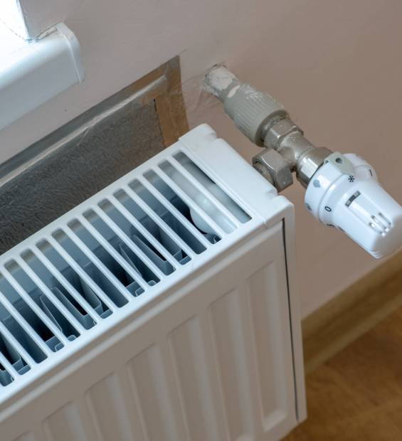 Closeup of heating radiator valve for comfortable temperature regulation on metal radiator on inrerior wall. Closeup of heating radiator valve for comfortable temperature regulation on metal radiator on inrerior wall.
